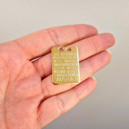 Waran bricka i förgyllt äkta silver. Graverad på svenska på ena sidan och engelska på andra sidan.