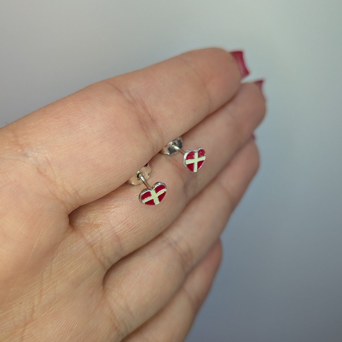 Örhängen hjärtformade i äkta silver. Danska flaggan i design med röd och vit emalj.