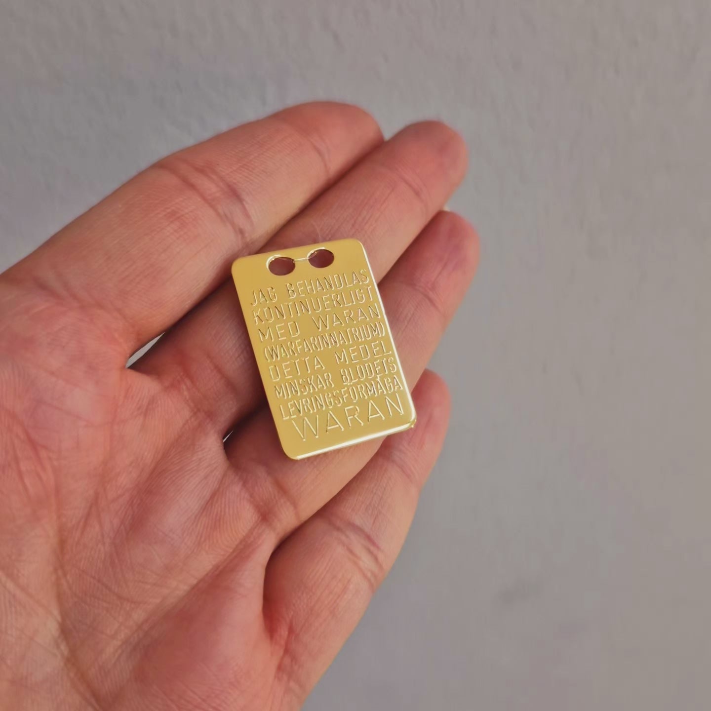 Waran bricka i förgyllt äkta silver. Graverad på svenska på ena sidan och engelska på andra sidan.